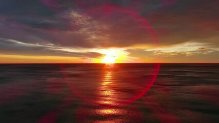 Wall Mural - aerial view of sea surface during a dramatic red sunset, 4k