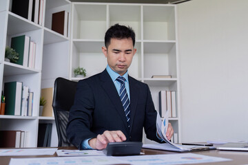 Professional accountant analyzing financial reports and calculating numbers in a modern office