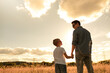 © kieferpix - parent and child father and son holding hands walking in nature park spending quality family time together