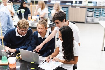 Fototapete - Diverse group of students collaborate in science lab. Diverse students, teamwork, and learning in school classroom. Diverse students collaborate in science class, teamwork group project at school