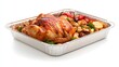 © NORN - Roasted Chicken Feast: A glistening roasted chicken, succulent and golden-brown, sits alongside roasted vegetables and lemon wedges in a foil pan, ready to be enjoyed as a festive centerpiece.