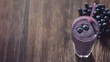 © agungai - a blueberry smoothie in a glass with a straw, isolated on a wooden surface background with copy space, a high-angle view