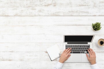 Poster - Minimalist Home Office Aesthetic Asian Man Typing on Laptop at Wooden Table with Coffee and Smartphone - Remote Work Innovation and Modern Productivity Solutions