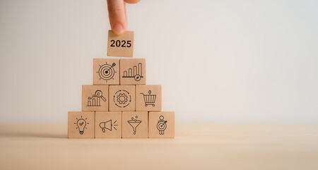 Wall Mural - 2025 business planning. Marketing and business strategy, goals and achievement concept. Wooden blocks featuring icons related to marketing, business strategies, digital marketing management.