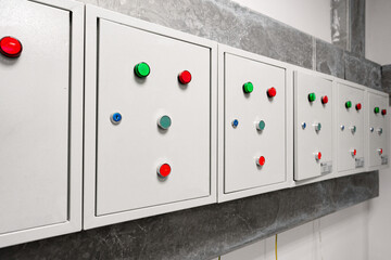 Poster - control panels with colored buttons mounted on a grey wall in a modern facility setting during dayli