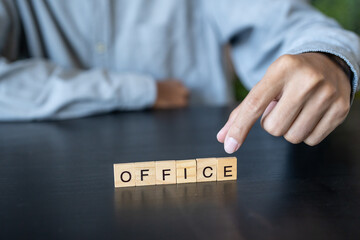 OFFICE concept. Business man hand holding wooden cube words OFFICE on a wood block