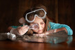 © Cavan Images - Young female girl looking through magnifying glass with goggles