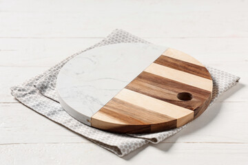 Empty cutting board with napkin on white wooden table, closeup