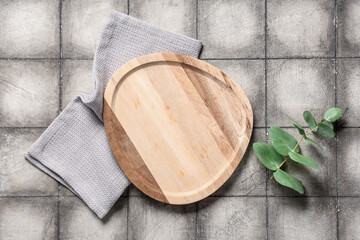 Wall Mural - Empty cutting board with napkin and eucalyptus branch on grey tiled table, top view