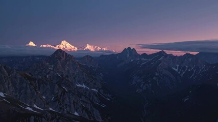 Poster - Majestic mountain range captures breathtaking sunset with snow-capped peaks in the backdrop near a tranquil valley