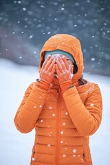 Poster - A person hiding their face from the cold and snow, possibly feeling overwhelmed or seeking solitude