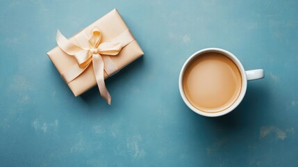 Poster - Top view of a white coffee cup filled with creamy coffee next to an elegant gift box with a ribbon on a dusty blue textured background
