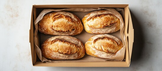 Poster - Freshly Baked Artisanal Bread in a Brown Kraft Box on a Light Gray Background Ideal for Culinary Text and Food Branding Promotions