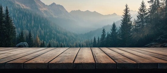 Poster - Empty wooden tabletop overlooking a serene mountain landscape with lush green forests and soft morning light in the background