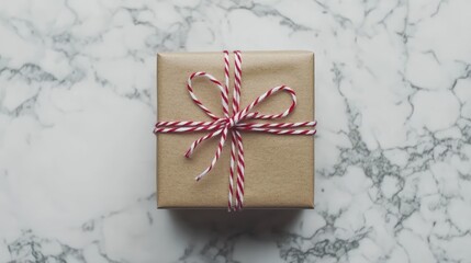 Aufkleber - Elegant top view of a brown gift box wrapped in red and white string on a marble surface, perfect for holiday celebrations and gifting themes.