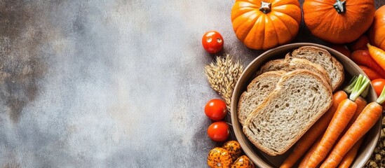 Aufkleber - Top view of a rustic bowl filled with brown bread, fresh carrots, and vibrant red tomatoes surrounded by orange pumpkins on a textured gray background with space for text