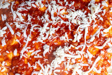 Wall Mural - Pizza texture background with tomato sauce and cheese. Raw pizza close-up.