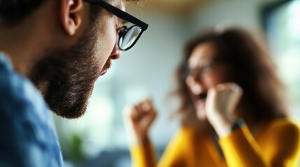 Poster - Man and woman sitting together looking at a laptop on a table in a modern indoor setting