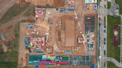 Canvas Print - Aerial view of construction site with cranes, foundations and building materials. Residential building under construction. Progress of new development in small town