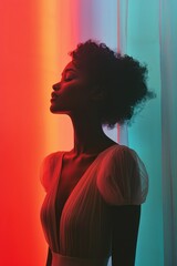 Wall Mural - Beautiful portrait of a woman with curly hair set against vibrant colored background in a creative studio