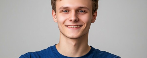 Sticker - Close up portrait of young smiling handsome guy in blue t-shirt isolated on gray background