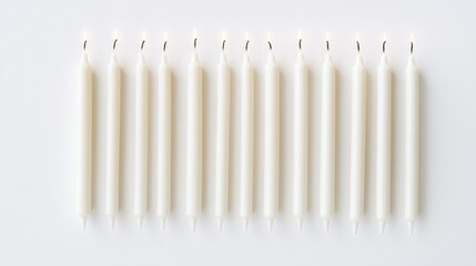 Leinwandbilder - Twelve elegantly arranged white candles on a clean white background for decorative and festive purposes.