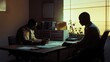 © Khaisan - Two individuals at a desk working under soft lighting in an office environment