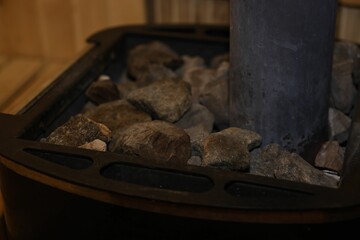 Wall Mural - Stove with hot rocks in sauna, closeup