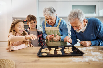 grandchild family child grandparent grandfather together grandmother cookie biscuit bake baking oven tasting eating dessert sweet holiday kitchen food