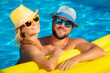 © Sunny studio - A couple in love posing in swimming pool on summer vacation