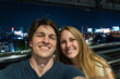 © Allison - City skyline night selfie of a couple enjoying their time together at a rooftop location