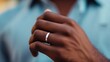 © SY - Close-up of a dark-skinned hand wearing a simple silver band. Ideal for concepts of commitment, love, or minimalism.