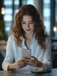 © Alexander Chaykin - Focused Young Woman Using a Phone in an Office Setting