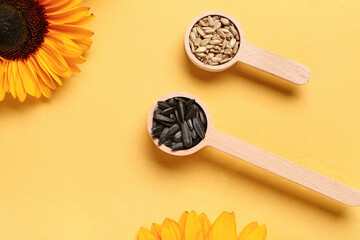 Wall Mural - Spoons with sunflower seeds on yellow background