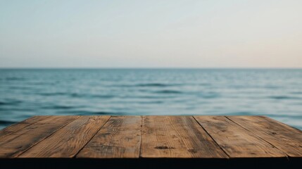 Poster - Empty wooden table overlooking tranquil ocean with blurred background