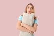 © Pixel-Shot - Thoughtful young woman with soft pillow on pink background