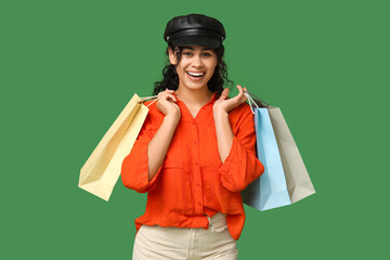 Sticker - Stylish African-American woman with shopping bags on green background