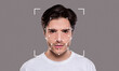 © Prostock-studio - A young man poses against a neutral background while facial recognition technology is applied. The highlights of his facial features are outlined with points and lines, emphasizing identification.
