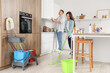 © Pixel-Shot - Cute young couple cleaning in kitchen together