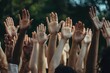 © Tanu - Many hands raised in unison during an outdoor gathering advocating for change in a community event
