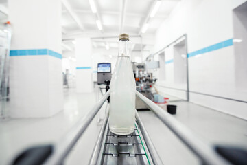 Poster - water bottle on conveyor belt in a modern beverage production facility during daylight hours