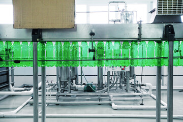 Poster - bottling process in a beverage production facility showcasing green bottles on the conveyor belt
