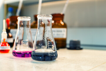 Poster - glass containers with colored liquids on laboratory countertop during scientific experiment in moder