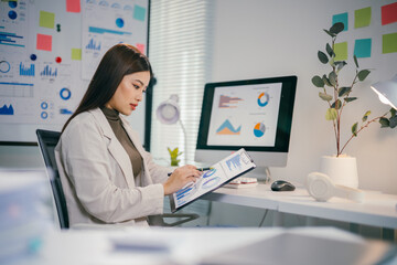 Poster - Professional asian businesswoman analyzing financial reports, examining charts, strategizing corporate growth in contemporary workspace