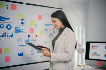 Poster - Young professional woman reviewing data and statistics, working on business project in modern office