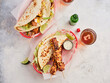 © Food Images - Two vibrant baskets feature grilled chicken skewers and loaded tacos garnished with fresh ingredients, lime wedges, and drinks in a lively atmosphere