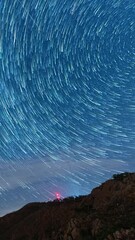 Wall Mural - endless night sky with star trail time lapse, vertical view