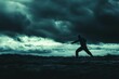© jambulart - Silhouetted figure wielding a sword, stormy sky.