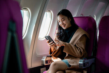 Poster - Professional female checking smartphone while flying, seated near aircraft window