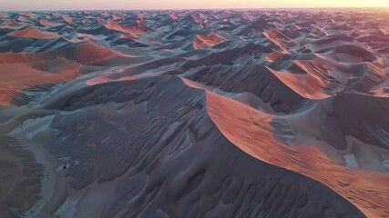 Poster - Vast desert landscape shows rolling sand dunes at sunset with vibrant colors across the horizon